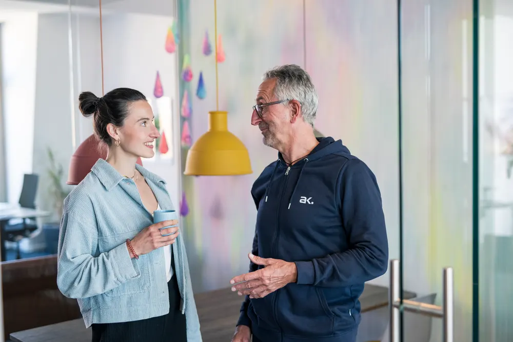 Gespräch im ak. Office vor der farbigen Wand